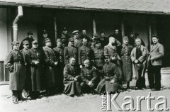 1940, Targu-Jiu, Rumunia.
Polscy żołnierze internowani w Rumunii; na zdjęciu grupa mężczyzn w wojskowych mundurach przed budynkiem, z prawej stoją trzej cywile.
Fot. NN, zbiory Ośrodka KARTA, udostępniła Barbara Tobijasiewicz.