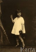 1925-1927, Nicea, Francja.
Larysa Zajączkowska trzymająca zabawkę. Zdjęcie wykonane w atelier fotograficznym.
Fot. NN, kolekcja Larysy Zajączkowskiej-Mitznerowej, zbiory Ośrodka KARTA