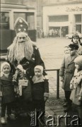Grudzień 1958, Poznań, Polska.
Mikołaj z dziećmi przed Domem Towarowym. Oryginalny podpis: „Kochanemu Stryjkowi podobiznę swoich pociech Elżuni i Andrzejka ofiaruje Ola Gwiazdro”.
Fot. ze zbiorów Archiwum Ojców Franciszkanów w Polskiej Misji Katolickiej w Martin Coronado w Argentynie, akta ojca Justyniana Maciaszka, reprodukcje cyfrowe w  Bibliotece Polskiej im. Ignacego Domeyki w Buenos Aires (Biblioteca Polaca Ignacio Domeyko) i w Ośrodku KARTA w Warszawie