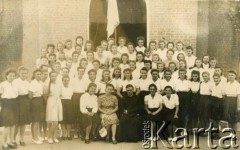 1943-1947, Kidugala, Tanganika.
Ojciec Justynian Maciaszek (1913-1959, proboszcz parafii w Kidugali, współtwórca ośrodka polskiego duszpasterstwa w argentyńskim Martin Coronado) z parafiankami.
Fot. ze zbiorów Archiwum Ojców Franciszkanów w Polskiej Misji Katolickiej w Martin Coronado w Argentynie, akta ojca Justyniana Maciaszka, reprodukcje cyfrowe w  Bibliotece Polskiej im. Ignacego Domeyki w Buenos Aires (Biblioteca Polaca Ignacio Domeyko) i w Ośrodku KARTA w Warszawie
