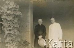 Prawdopodobnie 1943-1947, Kidugala, Tanganika.
Ojciec Justynian Maciaszek (1913-1959, proboszcz parafii w Kidugali, współtwórca ośrodka polskiego duszpasterstwa w argentyńskim Martin Coronado) z księdzem katolickim.
Fot. ze zbiorów Archiwum Ojców Franciszkanów w Polskiej Misji Katolickiej w Martin Coronado w Argentynie, akta ojca Justyniana Maciaszka, reprodukcje cyfrowe w  Bibliotece Polskiej im. Ignacego Domeyki w Buenos Aires (Biblioteca Polaca Ignacio Domeyko) i w Ośrodku KARTA w Warszawie