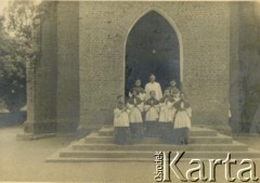 1943-1947, Kidugala, Tanganika.
Ojciec Justynian Maciaszek (1913-1959, proboszcz parafii w Kidugali, współtwórca ośrodka polskiego duszpasterstwa w argentyńskim Martin Coronado) z ministrantami.
Fot. ze zbiorów Archiwum Ojców Franciszkanów w Polskiej Misji Katolickiej w Martin Coronado w Argentynie, akta ojca Justyniana Maciaszka, reprodukcje cyfrowe w  Bibliotece Polskiej im. Ignacego Domeyki w Buenos Aires (Biblioteca Polaca Ignacio Domeyko) i w Ośrodku KARTA w Warszawie