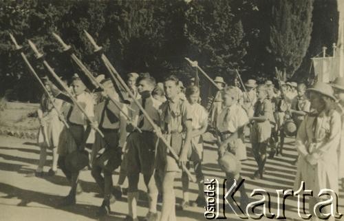 1943-1947, Kidugala, Tanganika.
Procesja w dniu Bożego Ciała. 
Fot. ze zbiorów Archiwum Ojców Franciszkanów w Polskiej Misji Katolickiej w Martin Coronado w Argentynie, akta ojca Justyniana Maciaszka, reprodukcje cyfrowe w  Bibliotece Polskiej im. Ignacego Domeyki w Buenos Aires (Biblioteca Polaca Ignacio Domeyko) i w Ośrodku KARTA w Warszawie