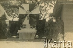 1943-1947, prawdopodobnie Kidugala, Tanganika.
Ołtarz polowy.
Fot. ze zbiorów Archiwum Ojców Franciszkanów w Polskiej Misji Katolickiej w Martin Coronado w Argentynie, akta ojca Justyniana Maciaszka, reprodukcje cyfrowe w  Bibliotece Polskiej im. Ignacego Domeyki w Buenos Aires (Biblioteca Polaca Ignacio Domeyko) i w Ośrodku KARTA w Warszawie