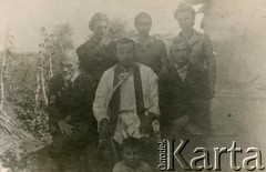 1942, Kazachstan, ZSRR.
Ojciec Łucjan Łuszczki (1910-1991, aresztowany i zesłany na Kołymę w 1940, w Armii Andersa od 1941, kapelan 6. Lwowskiej Brygady Piechoty, po wojnie pracował w Anglii, Walii i Szkocji, w latach 1960-1971 rektor Polskiej Misji Katolickiej w Argentynie, od 1971 pracował w parafii św. Brunona w Chicago) z polskimi zesłańcami.
Fot. NN, akta ojca Łucjana Łuszczki, zbiory  Archiwum Ojców Franciszkanów w Polskiej Misji Katolickiej w Martin Coronado, reprodukcje cyfrowe w Bibliotece Polskiej im. Ignacego Domeyki w Buenos Aires (Biblioteca Polaca Ignacio Domeyko) i w Ośrodku KARTA w Warszawie