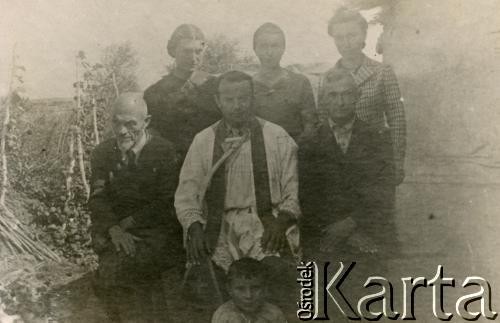 1942, Kazachstan, ZSRR.
Ojciec Łucjan Łuszczki (1910-1991, aresztowany i zesłany na Kołymę w 1940, w Armii Andersa od 1941, kapelan 6. Lwowskiej Brygady Piechoty, po wojnie pracował w Anglii, Walii i Szkocji, w latach 1960-1971 rektor Polskiej Misji Katolickiej w Argentynie, od 1971 pracował w parafii św. Brunona w Chicago) z polskimi zesłańcami.
Fot. NN, akta ojca Łucjana Łuszczki, zbiory  Archiwum Ojców Franciszkanów w Polskiej Misji Katolickiej w Martin Coronado, reprodukcje cyfrowe w Bibliotece Polskiej im. Ignacego Domeyki w Buenos Aires (Biblioteca Polaca Ignacio Domeyko) i w Ośrodku KARTA w Warszawie