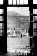 Początek XX wieku, Comodoro Rivadavia, prowincja Chubut, Argentyna.
Widok na górę Chenque przez otwarte drzwi stacji kolejowej. W głębi widać pomnik argentyńskiego bohatera narodowego San Martina. 
Fot. NN, zbiory Museo Ferroportuario w Comodoro Rivadavia, reprodukcje cyfrowe w  Bibliotece Polskiej im. Ignacego Domeyki w Buenos Aires (Biblioteca Polaca Ignacio Domeyko) i w Ośrodku KARTA w Warszawie
