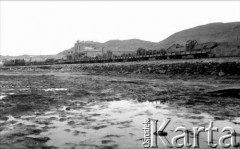 1928, Comodoro Rivadavia, prowincja Chubut, Argentyna.
Nabrzeże Atlantyku (Zatoka San Jorge) i budynek stacji kolejowej (w głębi). Fotografia wykonana z plaży w czasie odpływu. 
Fot. NN, zbiory Museo Ferroportuario w Comodoro Rivadavia, reprodukcje cyfrowe w  Bibliotece Polskiej im. Ignacego Domeyki w Buenos Aires (Biblioteca Polaca Ignacio Domeyko) i w Ośrodku KARTA w Warszawie