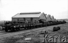 1934, Comodoro Rivadavia, prowincja Chubut, Argentyna.
Pociąg przy magazynie.
Fot. NN, zbiory Museo Ferroportuario w Comodoro Rivadavia, reprodukcje cyfrowe w  Bibliotece Polskiej im. Ignacego Domeyki w Buenos Aires (Biblioteca Polaca Ignacio Domeyko) i w Ośrodku KARTA w Warszawie