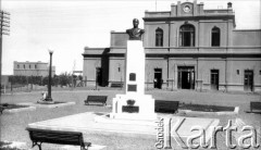 Początek XX wieku, Comodoro Rivadavia, prowincja Chubut, Argentyna.
Stacja kolejowa. Przed nią stoi pomnik argentyńskiego bohatera narodowego San Martina. 
Fot. NN, zbiory Museo Ferroportuario w Comodoro Rivadavia, reprodukcje cyfrowe w  Bibliotece Polskiej im. Ignacego Domeyki w Buenos Aires (Biblioteca Polaca Ignacio Domeyko) i w Ośrodku KARTA w Warszawie