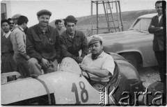 1955, Comodoro Rivadavia, prowincja Chubut, Argentyna.
Jan Józef Koprowski (pierwszy z lewej) - ojciec Enrique Koprowskiego - z kolegami. W samochodzie siedzi kierowca wyścigowy.
Fot. NN, zbiory Enrique Koprowskiego, reprodukcje cyfrowe w Bibliotece Polskiej im. Ignacego Domeyki w Buenos Aires (Biblioteca Polaca Ignacio Domeyko) i w Ośrodku KARTA w Warszawie.