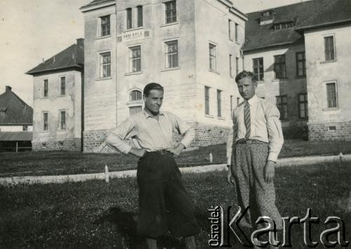 Lata 30., Buczacz, Polska.
Stefan Szymula (1. z lewej) - przed wojną pracował w Powiatowym Zarządzie Drogowym w Buczaczu. Po wrześniu 1939 ukrywał się. Aresztowany po nieudanej ucieczce do Rumunii, osadzony w więzieniu w Czortkowie, później w Starobielsku. Skazany na 5 lat obozu, zesłany w styczniu 1941 roku na Syberię. Dostał się do Armii Andersa, z którą został ewakuowany do Iranu. Przeszedł z nią cały szlak bliskowschodni. W Palestynie ukończył Szkołę Podchorążych Piechoty Rezerwy i został mianowany porucznikiem. Walczył pod Monte Cassino, w dniu zakończenia wojny ożenił się z Włoszką Silvią Valli. W 1948 roku emigrował do Argentyny. Na zdjęciu z kolegą przy budynku Obozu Obrony Przeciwlotniczej i Gazowej.
Fot. NN, zbiory Silvii Szymuli, reprodukcje cyfrowe w  Bibliotece Polskiej im. Ignacego Domeyki w Buenos Aires (Biblioteca Polaca Ignacio Domeyko) i w Ośrodku KARTA w Warszawie