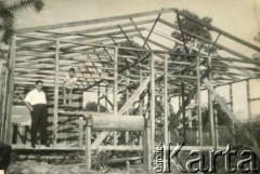 Lata 60., El Alcazar, prowincja Misiones, Argentyna.
Stefan Szymula z synem Benicio przy szkielecie swojego nowego domu. Przed wojną pracował w Powiatowym Zarządzie Drogowym w Buczaczu, po 1939 ukrywał się. Aresztowany po nieudanej ucieczce do Rumunii, osadzony w więzieniu w Czortkowie, później w Starobielsku. Skazany na 5 lat obozu, zesłany w styczniu 1941 roku na Syberię. Dostał się do Armii Andersa, z którą został ewakuowany do Iranu. Przeszedł z nią cały szlak bliskowschodni. W Palestynie ukończył Szkołę Podchorążych Piechoty Rezerwy i został mianowany porucznikiem. Walczył pod Monte Cassino, w dniu zakończenia wojny ożenił się z Włoszką Silvią Valli. W 1948 roku emigrował do Argentyny.
Fot. NN, zbiory Silvii Szymuli, reprodukcje cyfrowe w  Bibliotece Polskiej im. Ignacego Domeyki w Buenos Aires (Biblioteca Polaca Ignacio Domeyko) i w Ośrodku KARTA w Warszawie