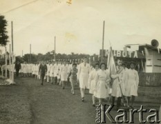 Ok. 1964., Puerto Rico, prowincja Misiones, Argentyna.
Claudio Szymula niesie flagę w czasie uroczystości szkolnej. Jego rodzice wzięli ślub w dniu zakończenia wojny. W 1948 roku emigrowali do Argentyny.
Fot. NN, zbiory Silvii Szymuli, reprodukcje cyfrowe w  Bibliotece Polskiej im. Ignacego Domeyki w Buenos Aires (Biblioteca Polaca Ignacio Domeyko) i w Ośrodku KARTA w Warszawie
