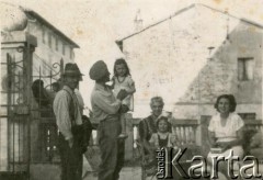 1944-1948, Scaperzano, Włochy.
Stefan Szymula z mieszkańcami miasteczka. Przed wojną pracował w Powiatowym Zarządzie Drogowym w Buczaczu, po 1939 ukrywał się. Aresztowany po nieudanej ucieczce do Rumunii, osadzony w więzieniu w Czortkowie, później w Starobielsku. Skazany na 5 lat obozu, zesłany w styczniu 1941 roku na Syberię. Dostał się do Armii Andersa, z którą został ewakuowany do Iranu. Przeszedł z nią cały szlak bliskowschodni. W Palestynie ukończył Szkołę Podchorążych Piechoty Rezerwy i został mianowany porucznikiem. Walczył pod Monte Cassino. W 1948 roku emigrował z żoną i synkiem do Argentyny.
Fot. NN, zbiory Silvii Szymuli, reprodukcje cyfrowe w  Bibliotece Polskiej im. Ignacego Domeyki w Buenos Aires (Biblioteca Polaca Ignacio Domeyko) i w Ośrodku KARTA w Warszawie