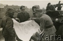 5.05.1945, Wilhelmshaven, Niemcy.
Niemiecka baza morska, która skapitulowała 5 maja 1945 roku. Kapitulację przyjął pułkownik Antoni Grudziński, zastępca dowódcy 10 Brygady Kawalerii Pancernej wchodzącej w skład 1 Dywizji Pancernej. Fotografia wykonana przed przyjęciem kapitulacji. 2. z prawej (w kapturze) porucznik Janusz Wincenty Barbarski z 2 Pułku Pancernego.
Fot. NN, zbiory Krzysztofa Barbarskiego, reprodukcje cyfrowe w Ośrodku KARTA w Warszawie i w Instytucie Polskim i Muzeum im. gen. Sikorskiego w Londynie.