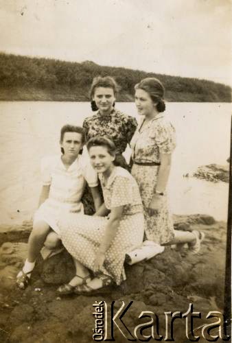 Ok.1945, Indie.
Od lewej: Krystyna Martusewicz, Aniela Wawrzyńczyk (po mężu  Zychowicz), Danuta Polak, Danuta Postek (na dole) na tle rzeki Panchaganga River w pobliżu polskiego obozu w Valivade na przedmieściach Kolhapuru.
Fot. NN, zbiory Anieli Zychowicz, reprodukcje cyfrowe w Ośrodku KARTA w Warszawie i w Instytucie Polskim i Muzeum im. gen. Sikorskiego w Londynie.