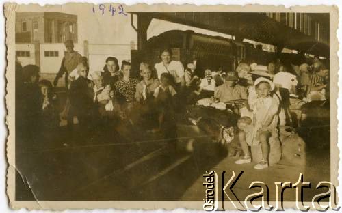 1942, brak miejsca.
Uchodźcy na stacji kolejowej, w trakcie podróży ze Związku Radzieckiego na południe. W środku, w białej koszuli Wiktoria Konop, z domu Marzec, z synem Ryszardem. 
Fot. NN, zbiory Ryszarda Konopa, reprodukcje cyfrowe w Ośrodku KARTA w Warszawie i w Instytucie Polskim i Muzeum im. gen. Sikorskiego w Londynie.