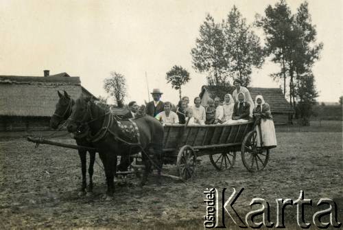 Lata 30., Polska.
Grupa osób na wozie zaprzęgniętym w konie.
Fot. NN, zbiory Joanny i Jacka Bernasińskich, reprodukcje cyfrowe w Ośrodku KARTA w Warszawie i w Instytucie Polskim i Muzeum im. gen. Sikorskiego w Londynie.