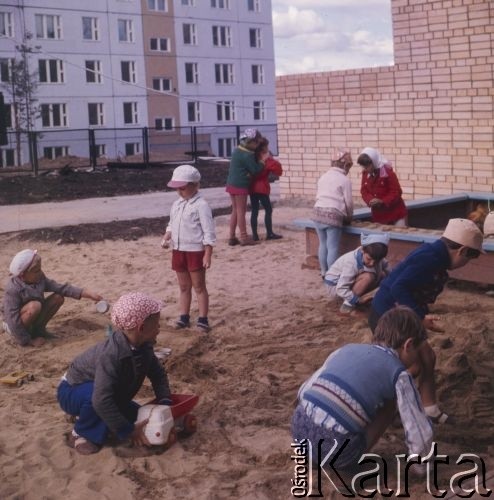 1977, Tynda, obwód amurski, Rosyjska Federacyjna Socjalistyczna Republika Radziecka, ZSRR.
Budowa Bajkalsko-Amurskiej Magistrali Kolejowej (BAM). Dzieci bawią się w piaskownicy na placu zabaw przy nowym osiedlu bloków wzniesionych w związku z budową magistrali i  dynamicznym rozwojem miasta.
Fot. Mikołaj Nesterowicz, zbiory Ośrodka KARTA