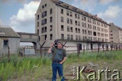 1993, Borne Sulinowo, woj. koszalińskie, Polska.
Realizacja reportażu Krystiana Przysieckiego o losach dawnego garnizonu wojskowego Armii Czerwonej i nowych mieszkańcach miasta. Autor zdjęć - Mikołaj Nesterowicz, stoi przed budynkiem byłych magazynów żywności w obrębie tankodromu.
Fot. Mikołaj Nesterowicz, zbiory Ośrodka KARTA