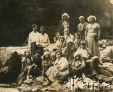 1934-1935, Worochta, woj. stanisławowskie, Polska.
Grupa osób nad rzeką. 1. z lewej na kamieniu siedzi Ewa Fiedorowicz z d. Cieńska (z dwoma warkoczami), 3. w białym kapeluszu Teresa Świdrygiełło-Świderska (później po mężu Somkowicz), 6. Maria 