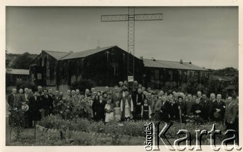 1.09.1952, Penrhos, Walia, Wielka Brytania.
Rezydenci Polskiego Osiedla dla byłych żołnierzy i ich rodzin. W tle widoczne zabudowania mieszkalne i żelazny krzyż zbudowany przez żołnierzy z Polskiego Komitetu Przysposobienia i Rozmieszczenia. W pierwszym rzędzie na środku stoją Leon Kowal i ksiądz Franciszek Ksawery Karkowski.
Fot. NN, kolekcja: Polskie Osiedle w Penrhos, reprodukcje cyfrowe w Ośrodku KARTA