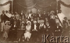 1933, Solec-Zdrój, woj. kieleckie, Polska.
Bal kostiumowy zorganizowany u Zofii i Andrzeja Dzianottów, rodziców Barbary Murzynowskiej. W pierwszym rzędzie 3. z lewej siedzi Anna Zgłuska (właścicielka apteki w Solcu), 4. Maria Łaszkiewicz ze Zborowa, 5. Andrzej Dzianott (ojciec Barbary, później po mężu Murzynowskiej). W drugim rzędzie 1. z prawej siedzi Rożniakowska. W ostatnim rzędzie 7. z lewej stoi Lucjan Czechowski, 9. Władysław Daniewski (wuj Barbary Murzynowskiej).
Fot. NN, kolekcja Barbary Murzynowskiej, reprodukcje cyfrowe w Ośrodku KARTA