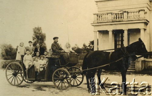 1943, Solec-Zdrój, Generalne Gubernatorstwo.
Dzieci w dorożce przed budynkiem łazienek dla kuracjuszy w uzdrowisku. W dorożce siedzi opiekunka dzieci Helena Trojanowska, na jej kolanach z lewej siedzi Paweł Daniewski, w środku  Marek Daniewski, za nim  Włodzimierz Daniewski. Obok Marka Daniewskiego z prawej na dole Barbara Dzianott (później po mężu Murzynowska). Na koźle przy furmanie stoi Krystyna Dzianott (starsza siostra Barbary Murzynowskiej, późniejsza żona Jacka Mappina).
Fot. NN, kolekcja Barbary Murzynowskiej, reprodukcje cyfrowe w Ośrodku KARTA