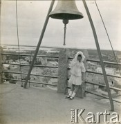 1918-1920, brak miejsca.
Wanda Plater-Zyberk (córka Antoniny i Henryka Michała hr. z Broelu, później matka Jana Murzynowskiego, męża Barbary Murzynowskiej) stoi pod dzwonem. 
Fot. NN, kolekcja Barbary Murzynowskiej, reprodukcje cyfrowe w Ośrodku KARTA