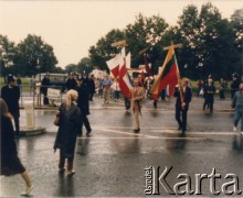 Lata 80., Londyn, Anglia, Wielka Brytania.
Hyde Park. Demonstracja zorganizowana przez grupę działaczy z ruchu Solidarity with Solidarity. Na pierwszym planie zwrócona w kierunku czoła pochodu stoi Tessa Ujazdowska (z opaską biało-czerwoną na ramieniu).  
Fot. NN, kolekcja Tessy Ujazdowskiej, reprodukcje cyfrowe w Ośrodku KARTA