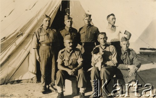 1944, prawdopodobnie Włochy. 
Grupa żołnierzy jednostki transportowej Polskich Sił Zbrojnych na Zachodzie przed namiotem. Z lewej siedzi Sławomir Szponar, ojciec Teresy Zapaśnik, z prawej pan Orlik (z osady Armatniów na Wołyniu, z której pochodzi rodzina Szponarów). Z tyłu fotografii dedykacja: 