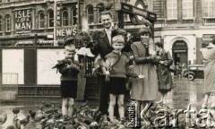 Ok. 1960, Londyn, Anglia, Wielka Brytania. 
Teresa Szponar (z prawej, później po mężu Zapaśnik) z mężem swojej starszej siostry Stefanii - Sławomirem Sobierajem i ich dziećmi: Edwardem (z lewej) i Robertem karmią gołębie na placu przy metrze. 
Fot. NN, kolekcja Teresy i Andrzeja Zapaśników, reprodukcje cyfrowe w Ośrodku KARTA