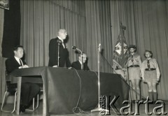 Lata 60., Londyn, Anglia, Wielka Brytania. 
Prawdopodobnie uroczysta akademia z okazji rocznicy uchwalenia Konstytucji 3 Maja. Przemawia gen. Władysław Anders (w środku). Z prawej na baczność stoi harcerz Andrzej Zapaśnik.
Fot. NN, kolekcja Teresy i Andrzeja Zapaśników, reprodukcje cyfrowe w Ośrodku KARTA