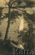 Lata 30., Narocz, woj. nowogródzkie, Polska.
Mężczyzna w kajaku z żaglem nad jeziorem Narocz.
Fot. NN, kolekcja Ireny Wolickiej-Wolszleger, reprodukcje cyfrowe w Ośrodku KARTA