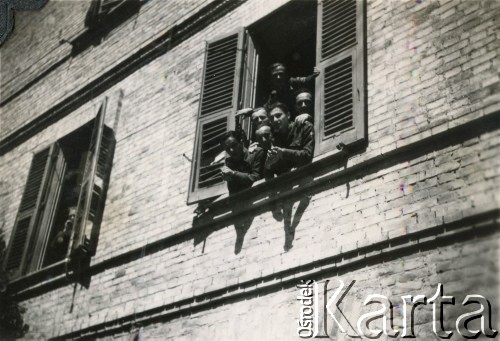 1945-1947, Włochy.
Grupa żołnierzy 2 Warszawskiej Brygady Pancernej 2 Korpusu Polskiego Polskich Sił Zbrojnych na Zachodzie wygląda przez okno kamienicy. 
Fot. NN, kolekcja: Polska Misja Katolicka, reprodukcje cyfrowe w Ośrodku KARTA