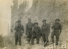 1944-1945, Cassino, Włochy.
Żołnierze 3 Brygady Strzelców Karpackich 2 Korpusu Polskiego Polskich Sił Zbrojnych na Zachodzie stoją pod zrujnowanym opactwem benedyktyńskim na szczycie Monte Cassino. 
Fot. NN, kolekcja: Polska Misja Katolicka, reprodukcje cyfrowe w Ośrodku KARTA