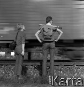 Lata 60., Warszawa (okolice), Polska.
Kobieta i mężczyzna na tle jadącego pociągu.
Fot. Marek Zürn, zbiory Fundacji Ośrodka KARTA