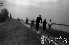 Lata 60., Warszawa (okolice), Polska.
Chłopcy na rowerach na wale przeciwpowodziowym na Wiśle pomiędzy Siekierkami a Górą Kalwarią.
Fot. Marek Zürn, zbiory Fundacji Ośrodka KARTA