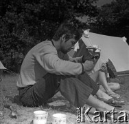 Lata 60., miejsce nieznane, Polska.
Spływ kajakowy, n/z uczestnik spływu podczas posiłku na biwaku.
Fot. Marek Zürn, zbiory Fundacji Ośrodka KARTA