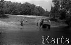 Lata 60., okolice Warszawy, Polska.
Nabieranie wody do baniaków na rzece Jeziorce.
Fot. Marek Zürn, zbiory Fundacji Ośrodka KARTA
