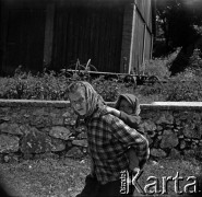 Lata 60., Mazowsze, Polska.
Kobieta niosąca dziecko na plecach.
Fot. Marek Zürn, zbiory Fundacji Ośrodka KARTA