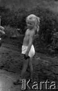 Lata 60., miejsce nieznane, Polska.
Dziecko wiejskie podczas zabawy na błotnistej drodze.
Fot. Marek Zürn, zbiory Fundacji Ośrodka KARTA