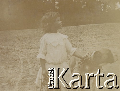 1900-1920, miejsce nieznane.
Prawdopodobnie córka Jadiwgi i Czesława Walińskich. Dziewczynka trzyma zebrane kwiaty i psa za obrożę. W tle drzewa.
Fot. NN, kolekcja rodziny Walińskich, zbiory Fundacji Ośrodka KARTA