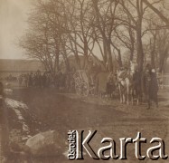 1900-1920, miejsce nieznane.
Wozy i konie ustawione w rzędzie. Na wozach i obok stoją mężczyźni. W oddali widać stajnię.
Fot. NN, kolekcja rodziny Walińskich, zbiory Fundacji Ośrodka KARTA