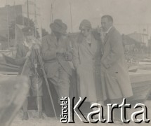 1920-1930, miejsce nieznane.
Spotkanie w porcie. Cztery osoby stoją obok łódki. W oddali widać budynki i łódki.
Fot. NN, kolekcja rodziny Walińskich, zbiory Fundacji Ośrodka KARTA