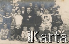 1920-1930, miejsce nieznane, Polska.
Portret grupowy. Dzieci z opiekunkami i księdzem.
Fot. NN, kolekcja rodziny Walińskich, zbiory Fundacji Ośrodka KARTA
