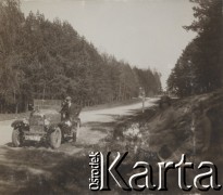 1930-1940, miejsce nieznane, Polska.
Samochód. Mężczyzna opiera się drzwi. Dwie kobiety siedzą na poboczu.
Fot. NN, kolekcja rodziny Walińskich, zbiory Fundacji Ośrodka KARTA