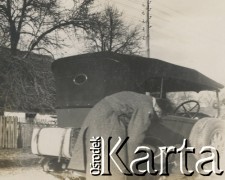 1930-1940, miejsce nieznane, Polska.
Mężczyźni sprawdzają koło w samochodzie.
Fot. NN, kolekcja rodziny Walińskich, zbiory Fundacji Ośrodka KARTA