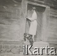 1930-1940, miejsce nieznane, Polska.
Kobieta zamyka lub otwiera drzwi. Obok stoi pies.
Fot. NN, kolekcja rodziny Walińskich, zbiory Fundacji Ośrodka KARTA